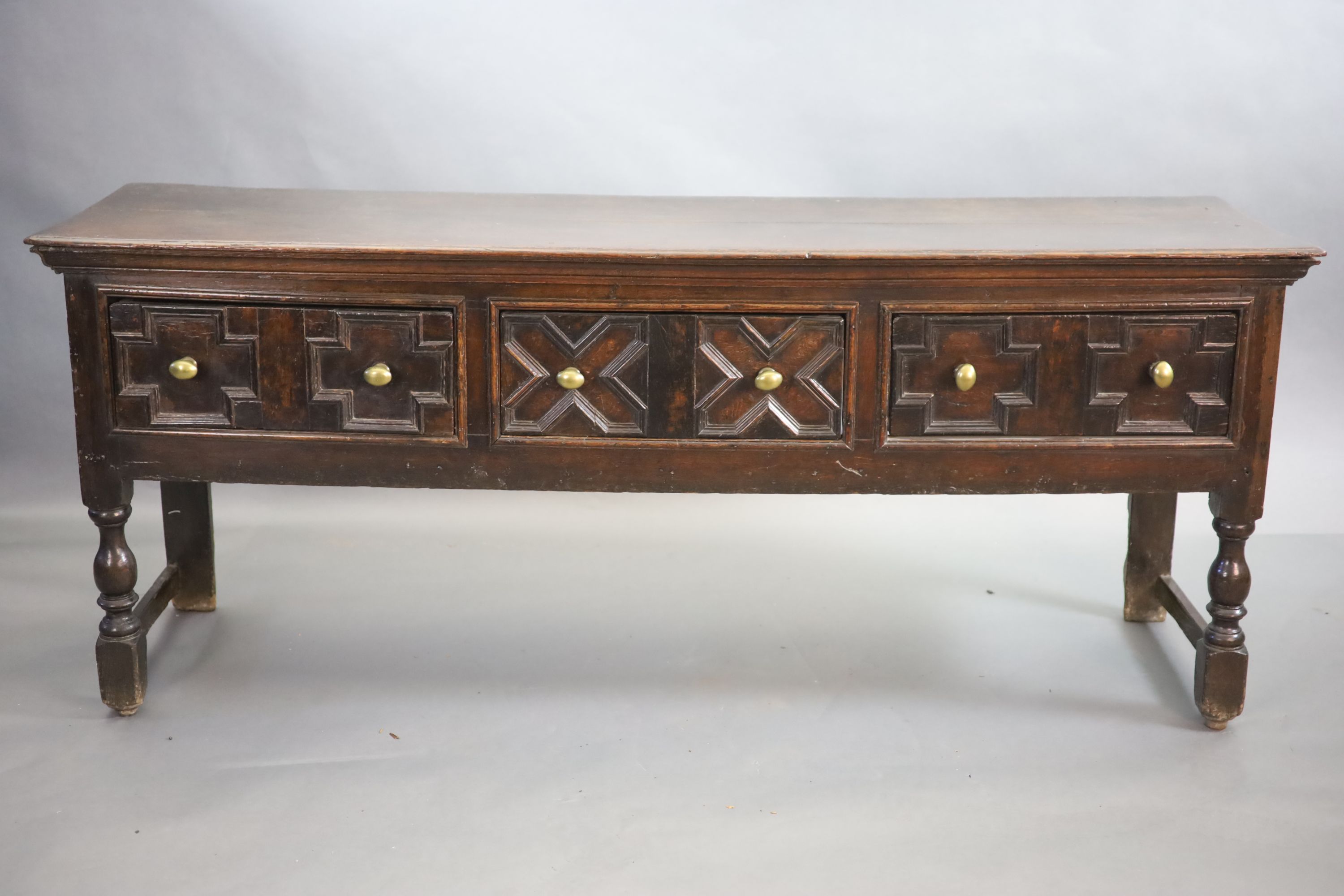 A late 17th century oak dresser fitted three short drawers raised on turned legs